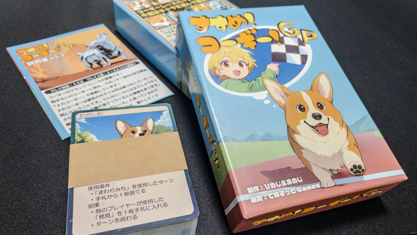 すすめ！コーギー！GPの箱、コーギーカード、イベントカードを卓上に並べた様子