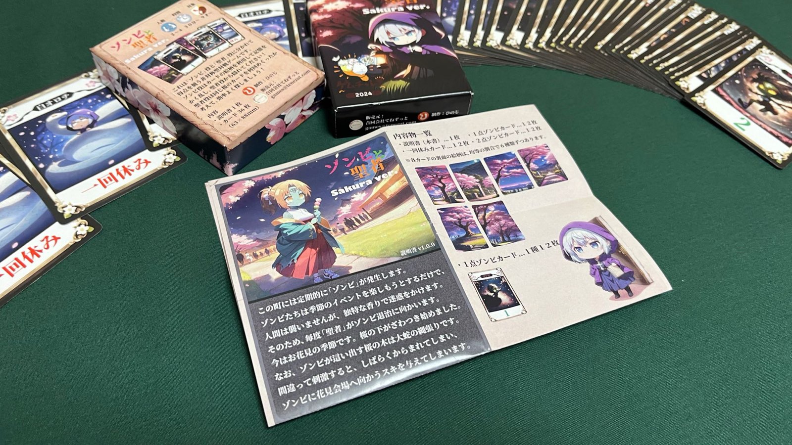 ゾンビと聖者 Sakura ver.の箱、カード、説明書を卓上に広げた様子